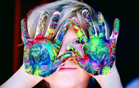 a kid with multicolored hand paint