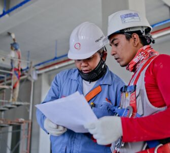 two man holding white paper