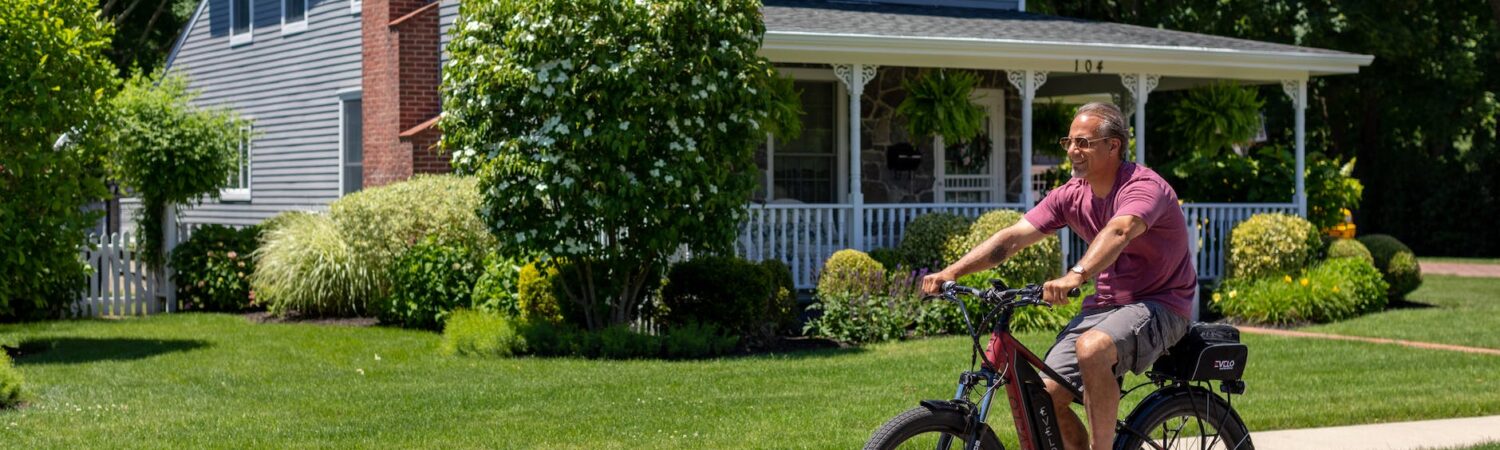 a man riding a bike on a street in front of a house