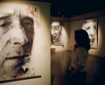 woman standing in front of man s painting