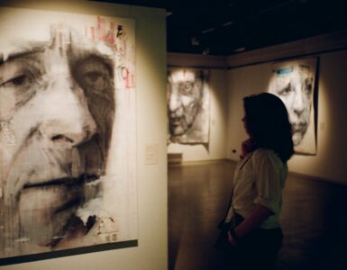 woman standing in front of man s painting