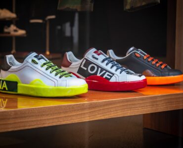 three unpaired multicolored leather sneakers on display