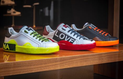 three unpaired multicolored leather sneakers on display