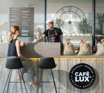 woman sitting on bar chair near barista