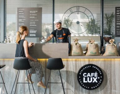 woman sitting on bar chair near barista