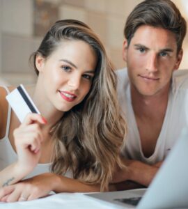 happy young couple doing purchase on internet together at home