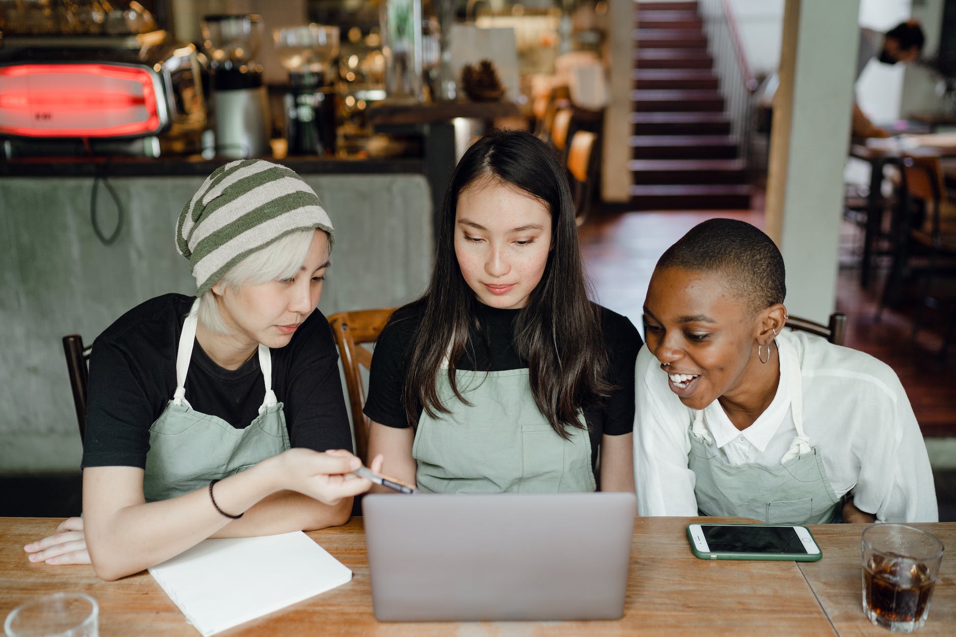 happy waitresses watching tutorials on laptop