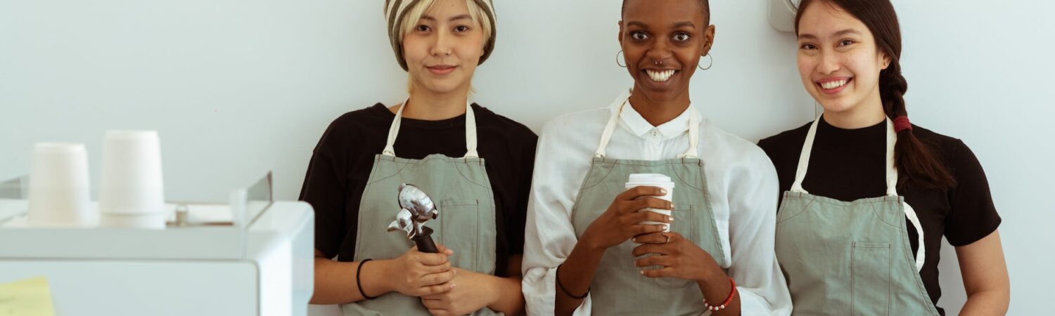 delighted baristas with portafilter and paper cup