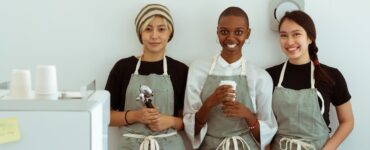 delighted baristas with portafilter and paper cup