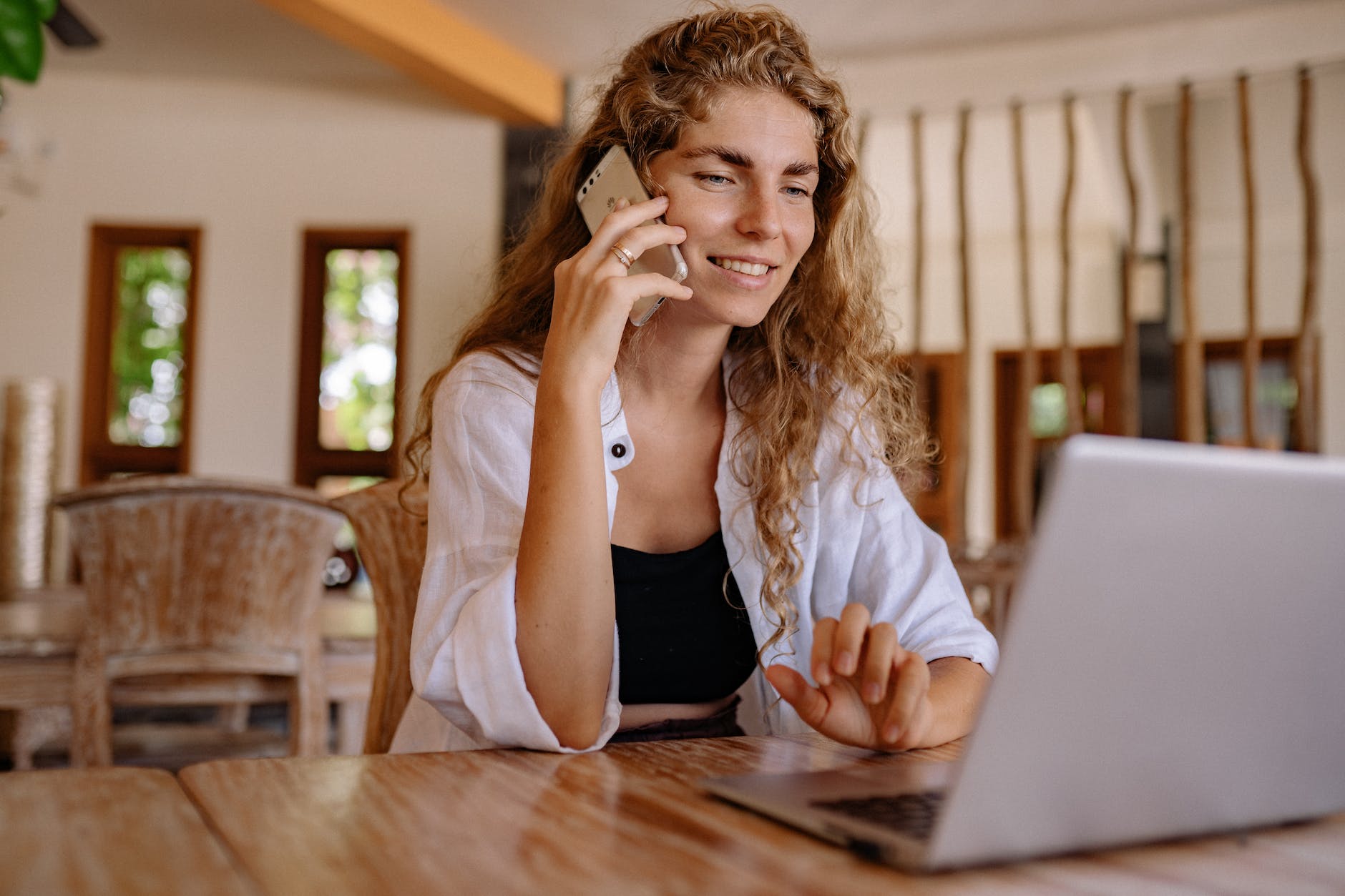 photo of woman using cellphone while smiling