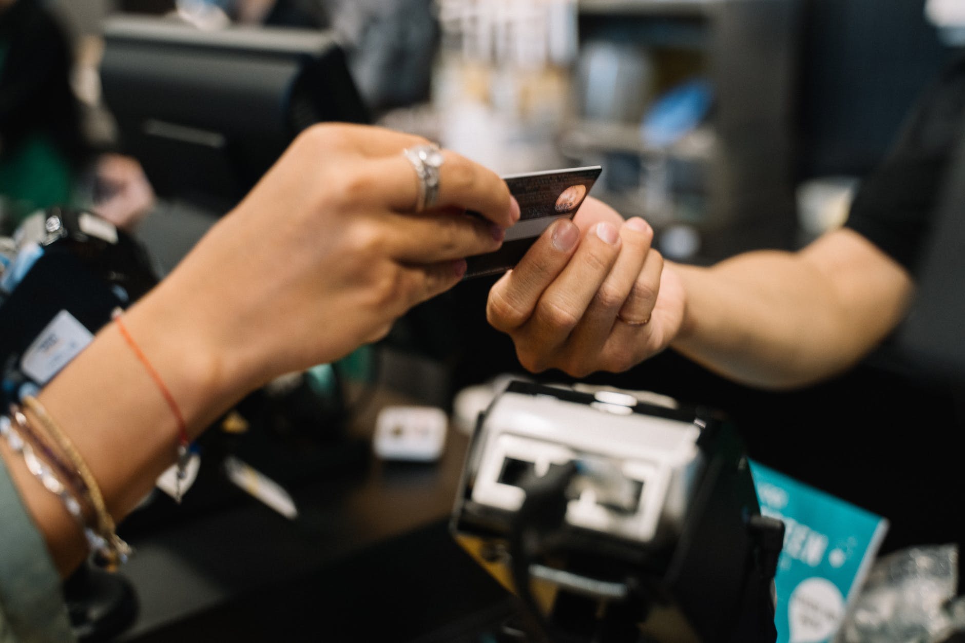 a person handing bank card to another person