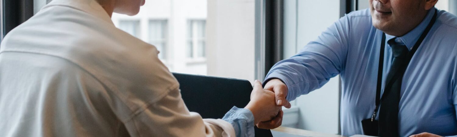 ethnic businessman shaking hand of applicant in office