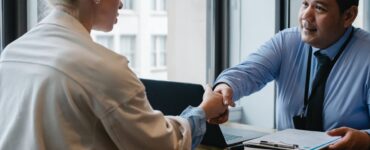 ethnic businessman shaking hand of applicant in office