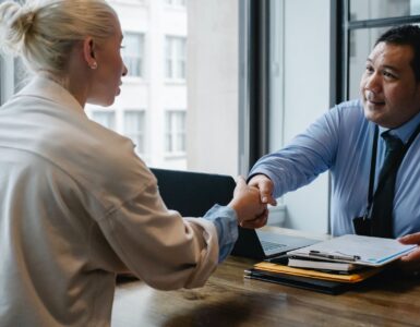 ethnic businessman shaking hand of applicant in office