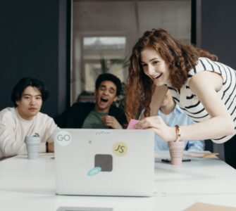 people laughing looking at a laptop