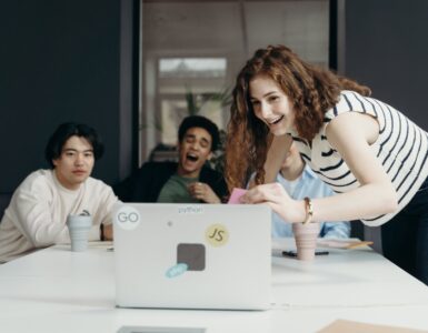 people laughing looking at a laptop