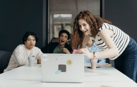 people laughing looking at a laptop