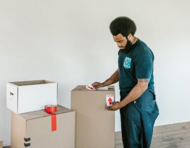 man putting caution stickers on cardboard boxes