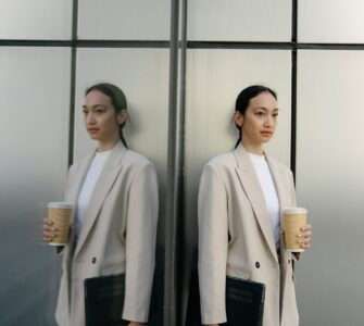 serious ethnic woman with takeaway coffee and laptop