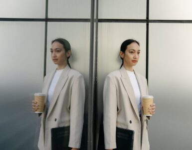 serious ethnic woman with takeaway coffee and laptop