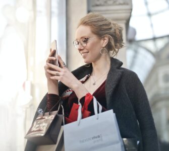 woman standing near wall holding phone