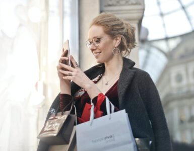 woman standing near wall holding phone